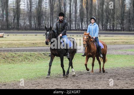 Non esclusiva: KYIV, UCRAINA - 2 APRILE 2022 - le donne cavalcano cavalli all'ippodromo di Kyiv, capitale dell'Ucraina. Foto Stock
