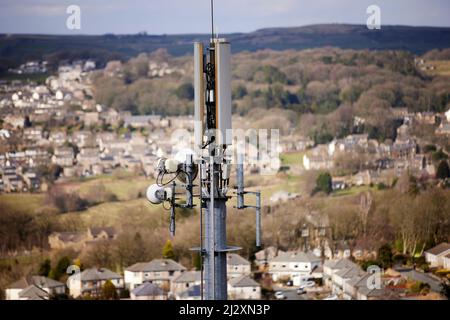 Un'antenna del palo del telefono mobile che torreggia sopra il villaggio di Yorkshire di Howarth Foto Stock