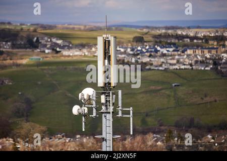 Un'antenna del palo del telefono mobile che torreggia sopra il villaggio di Yorkshire di Howarth Foto Stock