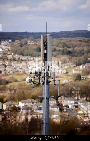 Un'antenna del palo del telefono mobile che torreggia sopra il villaggio di Yorkshire di Howarth Foto Stock