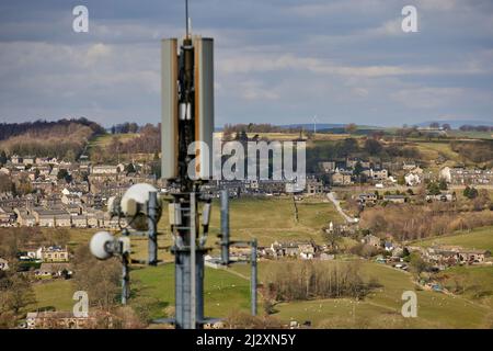 Un'antenna del palo del telefono mobile che torreggia sopra il villaggio di Yorkshire di Howarth Foto Stock
