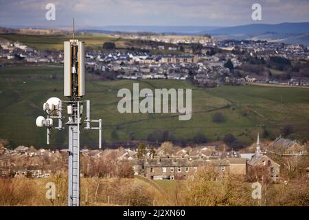 Un'antenna del palo del telefono mobile che torreggia sopra il villaggio di Yorkshire di Howarth Foto Stock