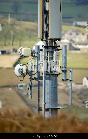 Un'antenna del palo del telefono mobile che torreggia sopra il villaggio di Yorkshire di Howarth Foto Stock