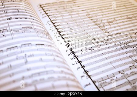 Musica manoscritto. Full frame, focus selettivo su una partitura del manoscritto orchestrale aperta. Foto Stock