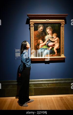 Londra, Regno Unito ( embargoed fino al 00,01 il 6th aprile 2022.) Un dipendente della galleria vede 'la Sacra Famiglia con il Bambino San Giovanni Battista (la Madonna della Rosa)'. La mostra Credit Suisse : Raffaello. Gallerie al primo piano, la Galleria Nazionale, Trafalgar Square. Foto Stock