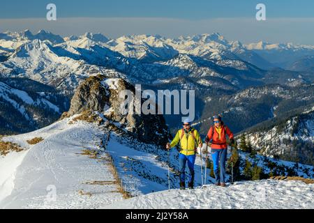 Uomo e donna che si snodano fino a Rotwand, Alpi bavaresi, Karwendel e Wetterstein sullo sfondo, Rotwand, Spitzing, Alpi bavaresi, alta Baviera, Baviera, Germania Foto Stock
