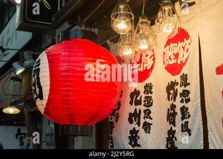 Lanterna di carta giapponese rossa classica appesa fuori di un ristorante a Ikebukuro, Tokyo, Giappone Foto Stock