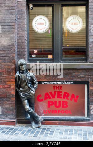 Lo statuto di John Lennon si appoggia contro il Wall of Fame al Cavern Pub di fronte a Mathew Street rispetto al Cavern Club Foto Stock