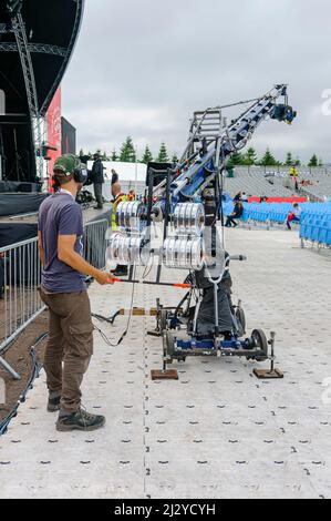 Un cameraman aziona una telecamera all'estremità di un braccio e di una sospensione cardanica. Foto Stock