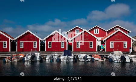 Boathouses rossi con barche sull'isola dell'arcipelago di Tjörn, nella parte occidentale della Svezia Foto Stock