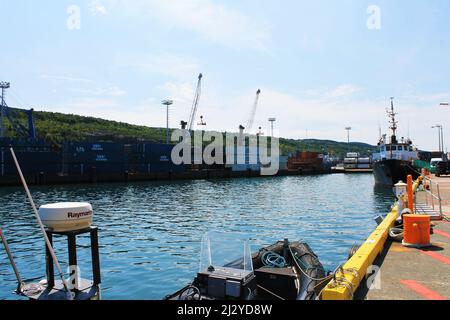 I contenitori di spedizione si accatastano su un molo, il porto di St. John. Foto Stock