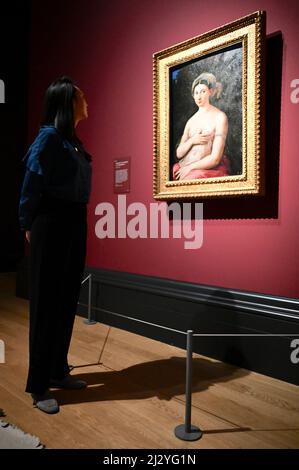 Londra, Regno Unito. (Imbarazzato fino alle 00,01 del 6th aprile 2022.) Anteprima stampa della mostra Credit Suisse : Raffaello, Gallerie First Floor, Galleria Nazionale, Trafalgar Square. Un dipendente di una galleria considera "Ritratto di una donna (la Fornarina)". Foto Stock