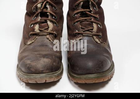 Stivali nubuck marroni - uno sporco, il secondo pulito su sfondo bianco. Cura delle scarpe. Foto Stock