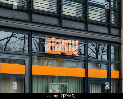 Logo DAK sulla facciata di un edificio. Compagnia di assicurazione sanitaria tedesca con cartello arancione. Lettere di affari di salute su un esterno dell'edificio. Foto Stock