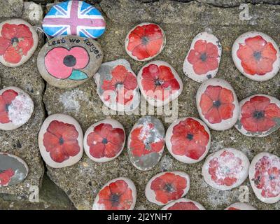 APPLEDORE, DEVON, INGHILTERRA - APRILE 2 2022: Fuori dalla chiesa parrocchiale di St Marys. Ciottoli di papavero dipinti, ricordo della guerra. Foto Stock