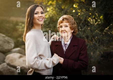 Mamma felice con la figlia che tiene le mani all'aperto nella foresta. Foto di alta qualità Foto Stock
