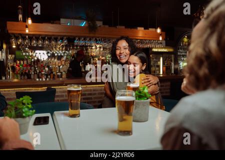 gruppo di amici diversi fuori per cena dando un abbraccio Foto Stock