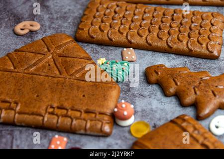 Parti e decorazioni della casa di pan di zenzero su sfondo grigio Foto Stock