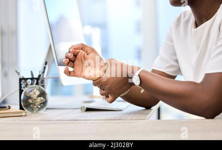 Ho bisogno di fare una pausa al polso. Colpo di una donna d'affari irriconoscibile che soffre di dolore al polso sul lavoro. Foto Stock