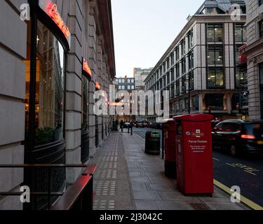 Street Off Piccadilly la sera con i segni al neon riflessi in una macchina e caselle postali in primo piano. Londra Foto Stock