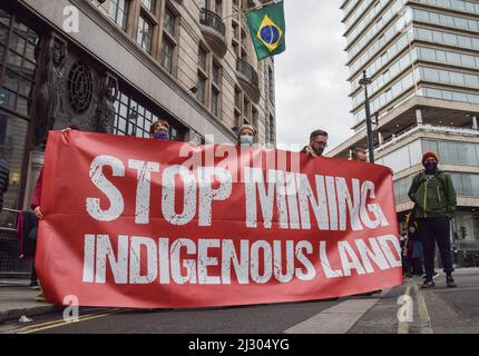 Londra, Regno Unito. 04th Apr 2022. I manifestanti hanno una bandiera "terra indigena di estrazione della cima" durante la manifestazione fuori dall'Ambasciata del Brasile a Londra. I manifestanti si sono riuniti in solidarietà con i popoli indigeni, mentre iniziano il loro campo di terra libera a Brasilia, e in protesta contro Bolsonaro, l'attacco ai diritti indigeni, alle miniere e alla distruzione della foresta pluviale amazzonica. (Foto di Vuk Valcic/SOPA Images/Sipa USA) Credit: Sipa USA/Alamy Live News Foto Stock