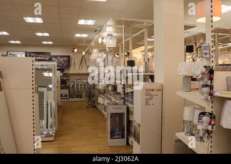 All'interno di un negozio di articoli per la casa, con mensole con lampade, specchi e plafoniere pensili Foto Stock