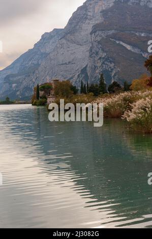 Lago Toblino con il castello in forma autunnale. È un piccolo lago alpino in provincia di Trento (Trentino-Alto Adige) ed è stato dichiarato Biotopo per le sue qualità naturalistiche. Posizione utilizzata per la produzione di pellicole. Italia Foto Stock