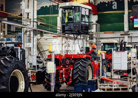 I lavoratori industriali assemblano il trattore agricolo in officina Foto Stock
