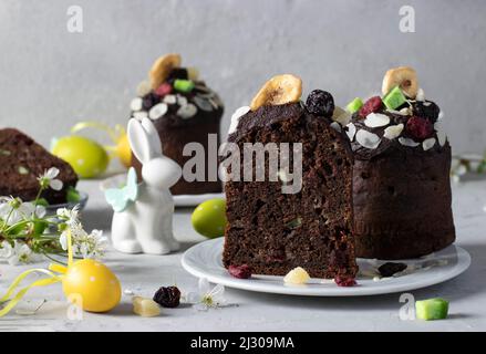 Dolci di Pasqua al cioccolato con frutta candita, nonché uova colorate su sfondo grigio. Pasqua primavera ancora vita Foto Stock