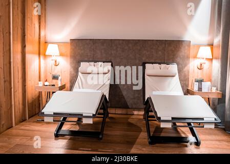 Sedie reclinabili vuote nelle camere illuminate del resort di lusso Foto Stock