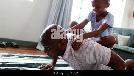 Felice il padre nero e il figlio che si legano, il ragazzino sul padre che torna a fare push-up Foto Stock