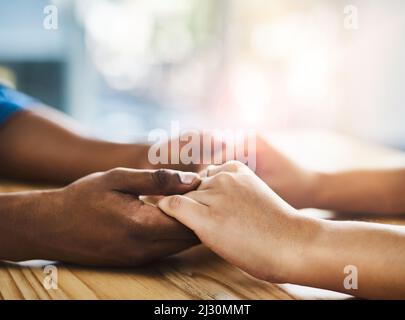 Sia forte per l'un l'altro. Scatto ritagliato di un uomo e di una donna non identificabili che tengono le mani su un tavolo. Foto Stock