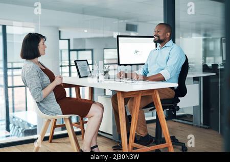 Grandi idee vengono in su nelle conversazioni. Scatto corto di due giovani uomini d'affari seduti in ufficio insieme e che hanno una discussione. Foto Stock