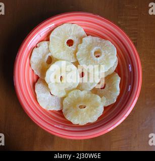 Fette di ananas essiccate in un recipiente in ceramica brillante Foto Stock