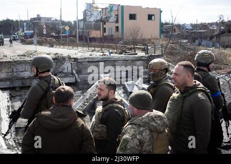 Il presidente ucraino Volodymyr Zelenskiy (C) si trova su un ponte distrutto nella città di Irpin, mentre l'attacco della Russia all'Ucraina continua. A Irpin in ucraino, il 4 aprile 2022. Il presidente ucraino Volodymyr Zelensky ha dichiarato il 3 aprile 2022 che la leadership russa era responsabile di uccisioni civili a Buca, fuori Kyiv, dove corpi sono stati trovati giacendo nella strada dopo che la città è stata ripresa dall'esercito ucraino. Lo stesso giorno il Ministero della Difesa russo ha respinto le accuse sostenendo che le forze russe hanno lasciato Bucha il 30 marzo, mentre le prove di uccisioni sono state presentate quattro giorni dopo. Pho Foto Stock