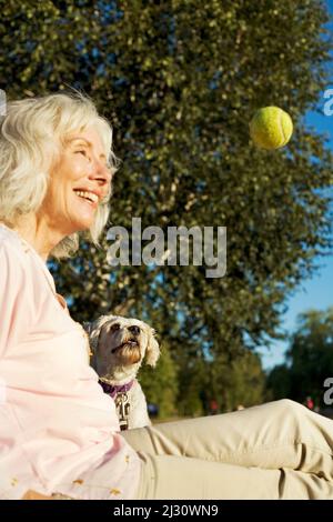 Donna anziana con il suo cane Cockapoo anziano Foto Stock