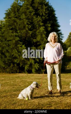 Donna anziana con il suo cane Cockapoo anziano Foto Stock