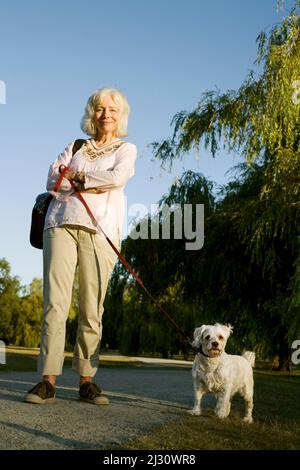 Donna anziana con il suo cane Cockapoo anziano Foto Stock