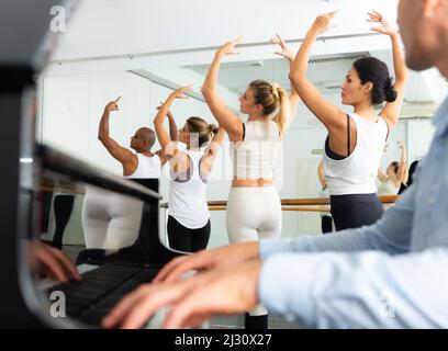 Gruppo di uomini e donne che praticano al balletto barre Foto Stock