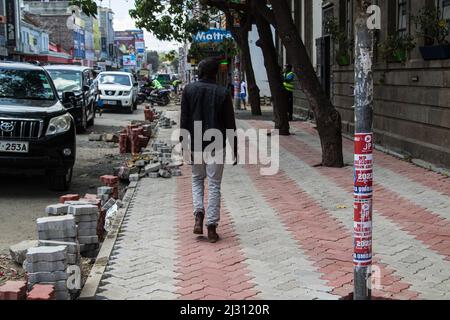 Nakuru, Kenya. 03rd Apr 2022. Un uomo è visto camminare su una passerella parzialmente pavimentata nel quartiere centrale degli affari. Da quando Nakuru è stato insignito del charter città alla fine dell'anno scorso, la città ha visto uno sviluppo di infrastrutture non motorizzate per facilitare l'ambiente a piedi e in bicicletta per gli abitanti della città. Il progetto è finanziato dalla Banca mondiale. (Foto di James Wakibia/SOPA Images/Sipa USA) Credit: Sipa USA/Alamy Live News Foto Stock