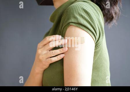 Vista ravvicinata del braccio della donna con bendaggio, immunizzazione vaccinata. Concetto di inoculazione o vaccinazione. Foto Stock
