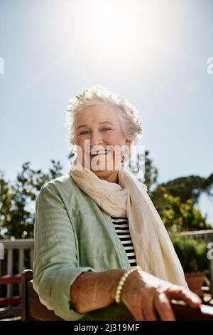 I giorni felici sono qui per rimanere. Ritratto di una donna anziana felice rilassante all'aperto. Foto Stock