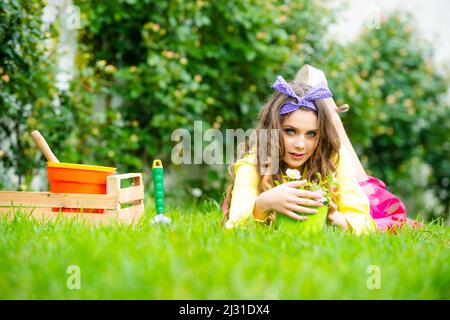 Ragazza adolescente che lavora in giardino. Fiorista felice ragazza teen in cortile. Giardinaggio e piantando fiori. Foto Stock