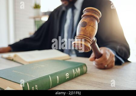 Abbiamo bisogno di ordine qui. Sparato di un avvocato irriconoscibile utilizzando un gavel al lavoro. Foto Stock