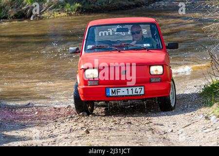 Madona, Lettonia - 01 maggio 2021: La Fiat 126, una vettura rossa a tempo indolo, supera l'ostacolo all'acqua Foto Stock