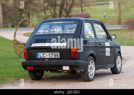 Madona, Lettonia - 01 maggio 2021: Colorata auto a noleggio PanCars Fiat 126 parcheggiata sul lato di una strada di campagna Foto Stock