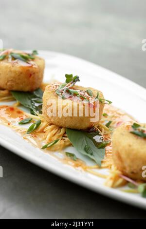 tradizionali torte thailandesi di granchio con salsa al peperoncino nel moderno ristorante di bangkok Foto Stock