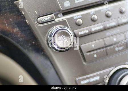 Un primo piano del pulsante del volume su un cruscotto audio di un'auto. Foto Stock