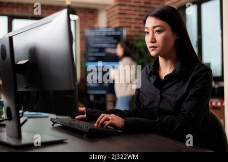 Cyber officer che lavora con numeri binari per lo sviluppo di applicazioni di database attraverso nodi neurali. Algoritmo di sicurezza per sviluppatori di software asiatici che utilizza la programmazione visiva. Foto Stock