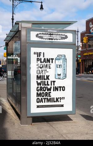 Un strano divertente e irriverente annuncio di latte di Oatly oat spiritoso in un rifugio di autobus a Broadway vicino Steinway St. Ad Astoria, Queens, New York. Foto Stock